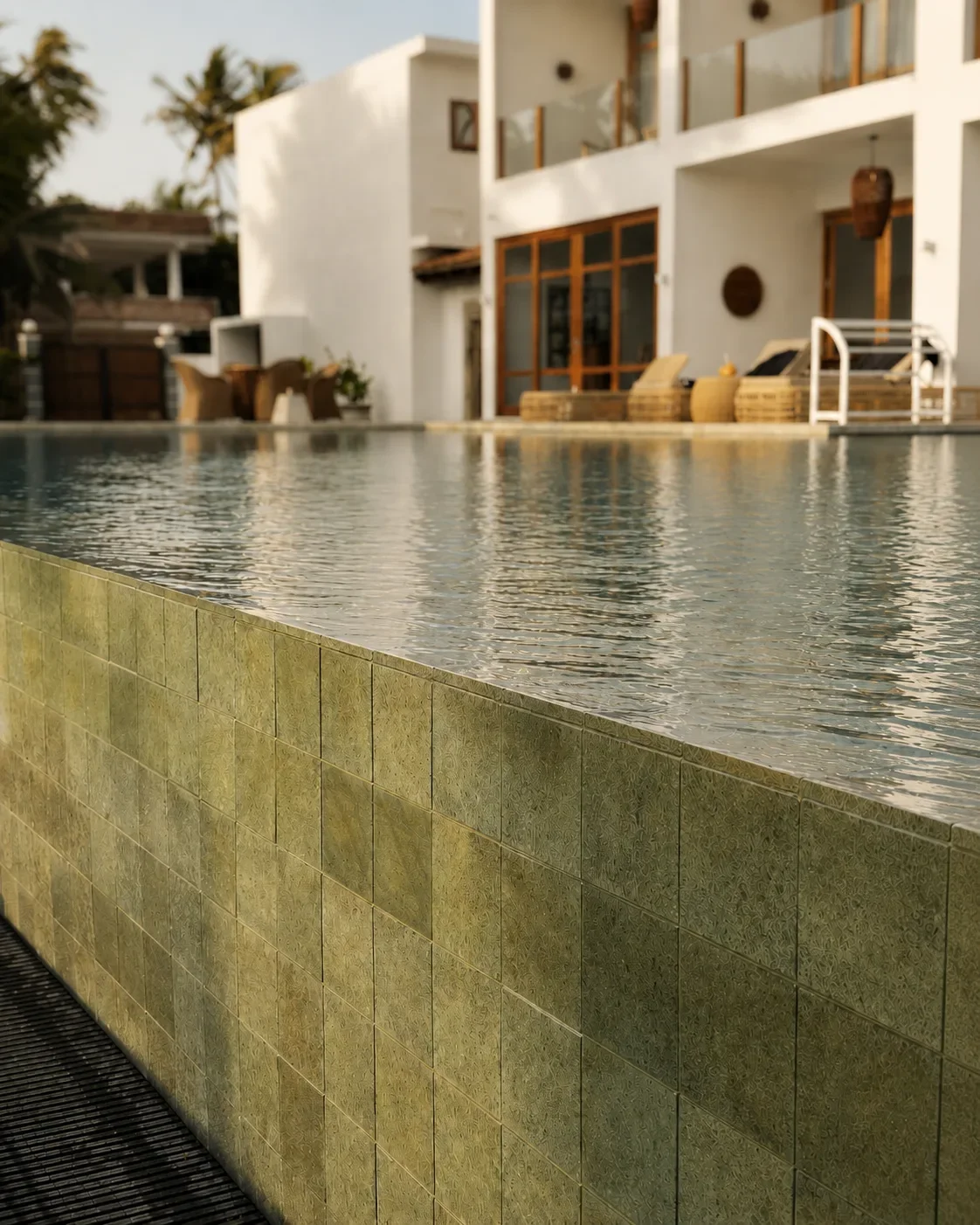 Infinity pool at Villa Lanka Flair with a tiled edge and a view of the main building