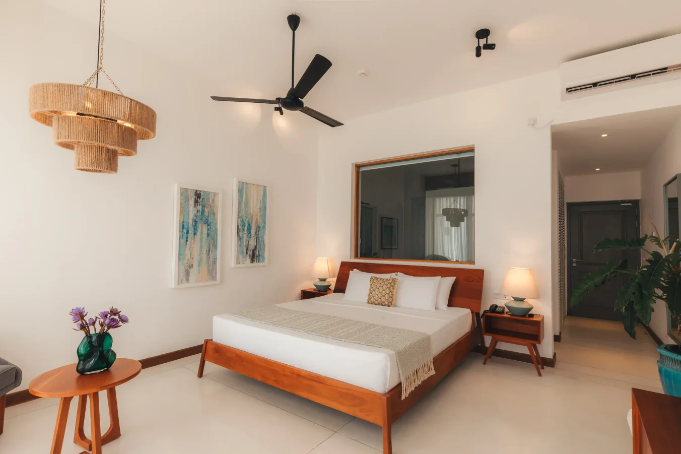 Kingsize-Bett im Ocean View Room mit Kopfteil aus dunklem Holz und großem Wandspiegel